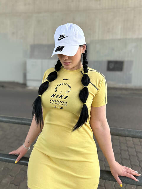 Girl wearing a yellow dress and a Nike white cap